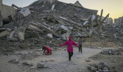 أطفال فلسطينيون يلعبون بجوار مبنى دمره قصف إسرائيلي وسط قطاع غزة | المصدر: أسوشييتد برس