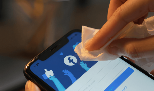 شخص يمسح هاتفه وهو يفتح تطبيق فيسبوك | تعبيرية