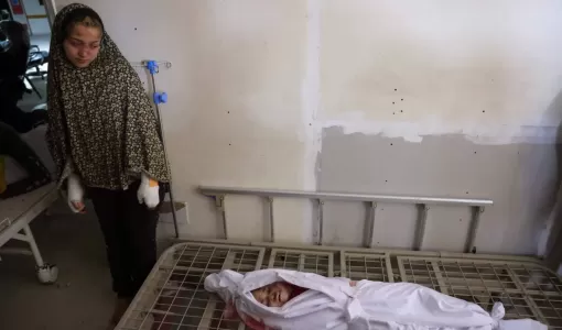 فلسطينية مصابة تنظر إلى جثمان شقيقها الذي استشهد في غارة إسرائيلية بالمستشفى الإندونيسي ببيت لاهيا شمال قطاع غزة 18/3/2025 | المصدر: وكالة الأنباء الفرنسية