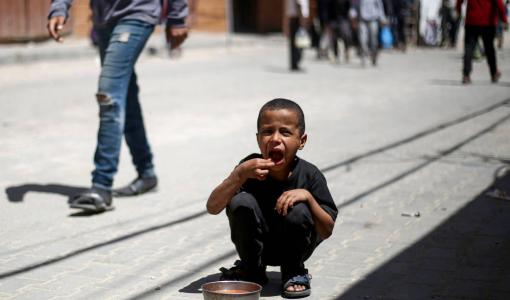 طفل يتناول حصة من الطعام في مخيم النصيرات للاجئين وسط قطاع غزة | المصدر: وكالة الأنباء الفرنسية