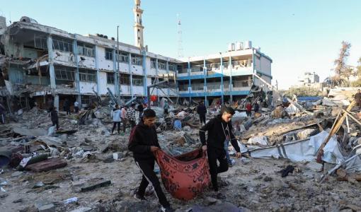 فلسطينيان يحملان جثة شهيد في مدرسة أبو هميسة فلسطينيان يحملان جثة شهيد في مدرسة أبو هميسة | المصدر: وكالة الأنباء الفرنسية