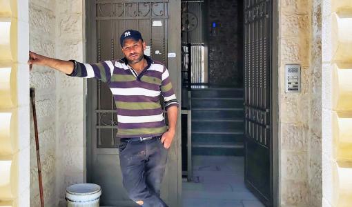 حارس أمام إحدى البنايات التي يعمل فيها في عمان | المصدر: حبر