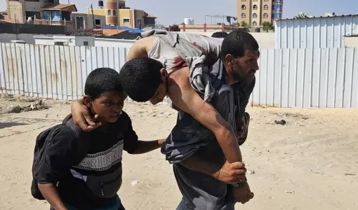 فلسطيني يحمل رجلا أصيب في أثناء وقوفه في طابور للحصول على مساعدات فلسطيني يحمل رجلا أصيب في أثناء وقوفه في طابور للحصول على مساعدات | المصدر: وكالة الأنباء الفرنسية