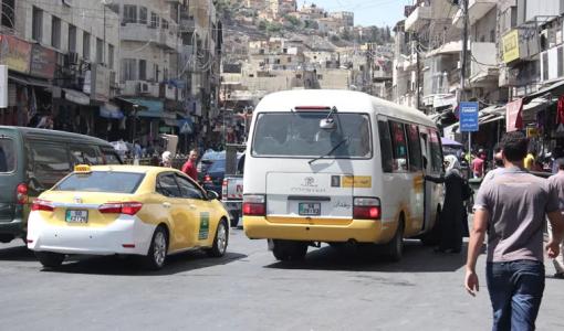 صورة أرشيفية لحافلة نقل عام وسيارة أجرة في وسط البلد في عمان | المصدر: حبر