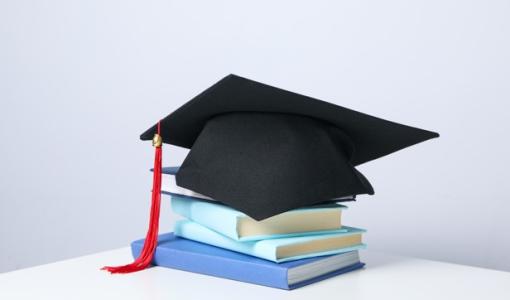 طاقية تخرج فوق كتب | تعبيرية freepik