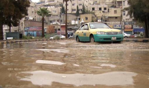 تكسي أصفر يقف بينما تغمر مياه الأمطار أحد شوارع العاصمة عمان | أرشيفية