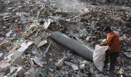 طفل فلسطيني يجمع البلاستيك بالقرب من صاروخ لم ينفجر في مكب نفايات بمدينة غزة 12/11/2025 | وكالة الأنباء الفرنسية