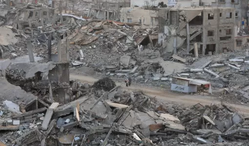 فلسطينيتان تسيران في طريق بين ركام ودمار هائل خلفته حرب الإبادة الإسرائيلية في غزة | المصدر: رويترز