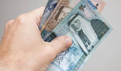 يد تمسك عدة أوراق نقدية أردنية من فئات مختلفة | تعبيرية