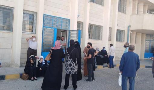 مجموعة من المواطنين ينتظرون أمام مدخل مركز صحي أبو نصير الشامل | أرشيفية