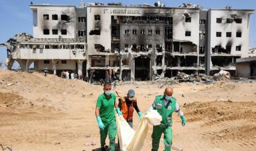 كوادر طبية تنقل جثامين من ساحة مجمع الشفاء الطبي