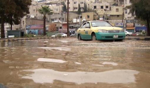 تكسي يسير في أحد شوارع العاصمة عمان وقد غمرته مياه الأمطار | مواقع التواصل