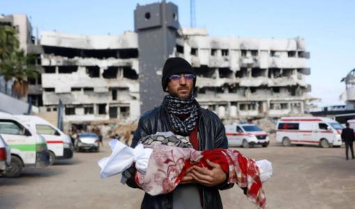 فلسطيني يحمل جثمان رضيعته البالغة 3 أشهر بعد وفاتها جراء البرد في مدينة غزة | وكالة الأنباء الفرنسية