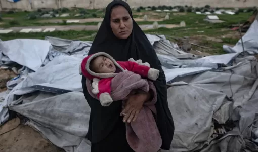 فلسطينية تحمل طفلها الرضيع بعد أن انهارت خيمتها في خانيونس جنوب قطاع غزة جراء الرياح القوية والأمطار | الوكالة الأوروبية للصور الصحفية