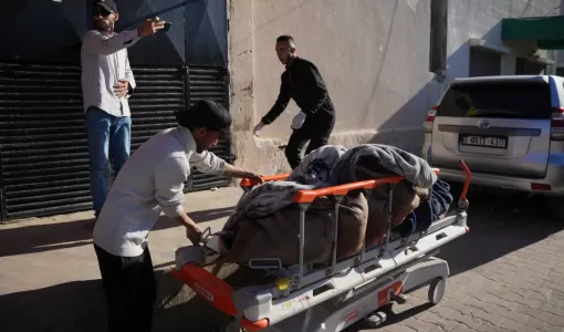 رجل فلسطيني يدفع نقالة تحمل جثمان شهيدين في مستشفى شهداء الأقصى 4/2/2026 | أسوشييتد برس