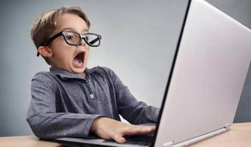 طفل يستخدم حاسوبا محمولا | تعبيرية