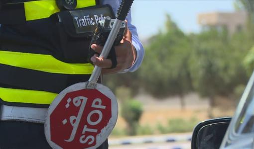 رجل سير يحمل شاخصة قف في أحد شوارع العاصمة عمان