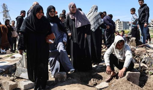 فلسطينيون حول قبر شهيدين من أقاربهم استهدفتهما غارة إسرائيلية في حي الشجاعية بمدينة غزة 28/3/2026 | وكالة الأنباء الفرنسية