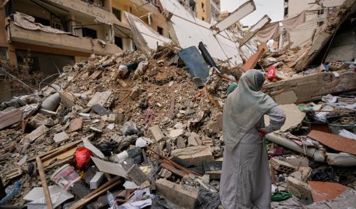 سيدة تقف أمام مبنى مدمر في الضاحية الجنوبية لبيروت | أسوشييتد برس