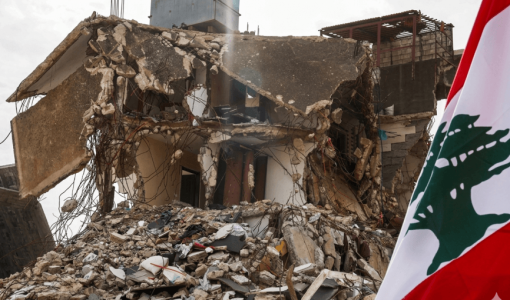 علم لبنان بجوار مبنى دمرته غارة إسرائيلية في قرية كفر كلا جنوب لبنان | رويترز