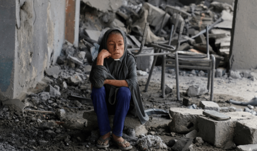 فتاة فلسطينية تجلس وسط الأنقاض في مدرسة تابعة للأمم المتحدة حيث كان النازحون يحتمون، بعد أن قصفها جيش الاحتلال في حي الزيتون بمدينة غزة | رويترز