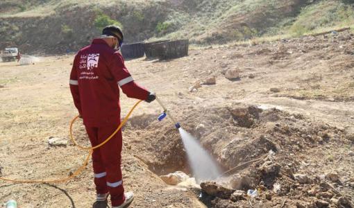 أحد كوادر أمانة عمان الكبرى يقوم برش مواد تعقيم داخل أحد مواقع ذبح الأضاحي | أمانة عمان