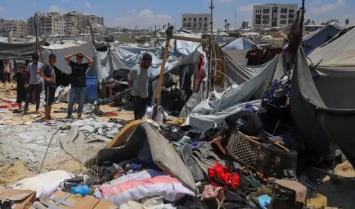 فلسطينيون يتفقدون موقع غارة إسرائيلية استهدفت خيمة في مخيم لإيواء النازحين بمدينة غزة | رويترز