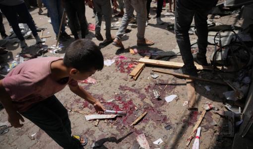 طفل فلسطيني يتفقد موقع غارة عسكرية إسرائيلية في دير البلح وسط غزة | أسوشييتد برس