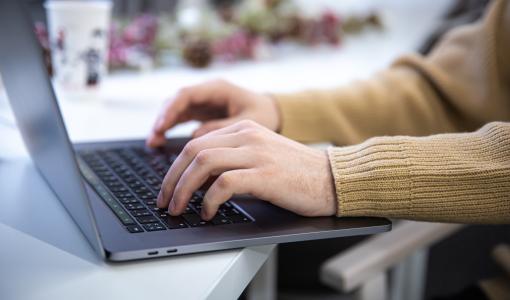 صورة تعبيرية لشخص يستخدم حاسوب محمول