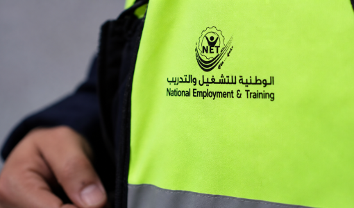 شخص يرتدي سترة عليها شعار الوطنية للتشغيل والتدريب