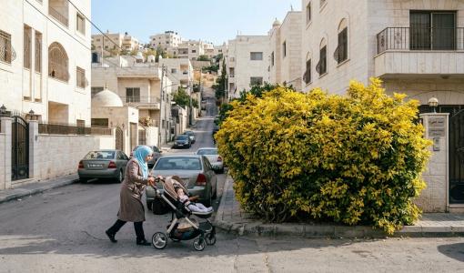 صورة مولدة بالذكاء الاصطناعي لأم تقود عربة أطفال على الشارع بسبب احتلال شجرة لجزء كبير من الرصيف