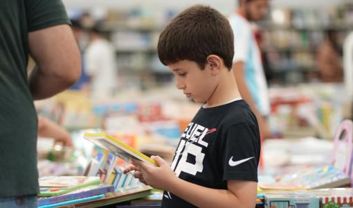 طفل يتجول في معرض عمان الدولي للكتاب 2025 | اتحاد الناشرين الأردنيين