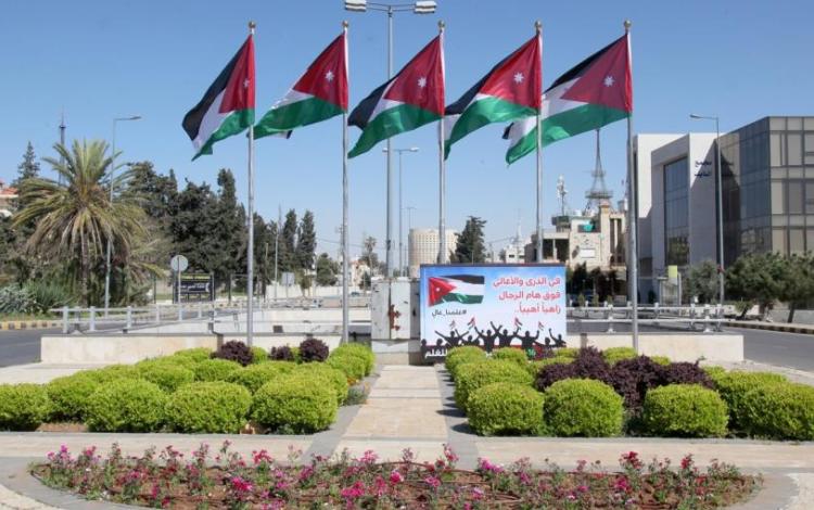 ساحة عامة تتوسطها أعلام الأردن مرفوعة على سوار
