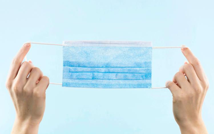 شخص يمسك قناع طبي | تعبيرية freepik