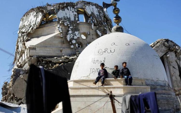 أطفال يجلسون بقرب قبة مسجد دمره جيش الاحتلال خلال حرب الإبادة في مدينة غزة 18/2/2026 | رويترز