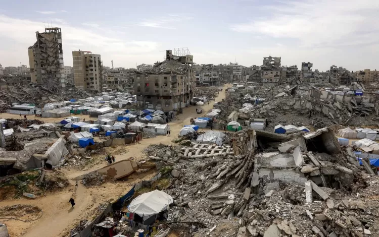 خيام تؤوي الفلسطينيين النازحين إلى جانب مبان مدمرة ومتضررة بشدة في غزة | وكالة الأنباء الفرنسية