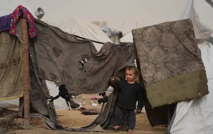 طفل فلسطيني ينظر من خارج خيمة في الزوايدة وسط قطاع غزة | أسوشييتد برس