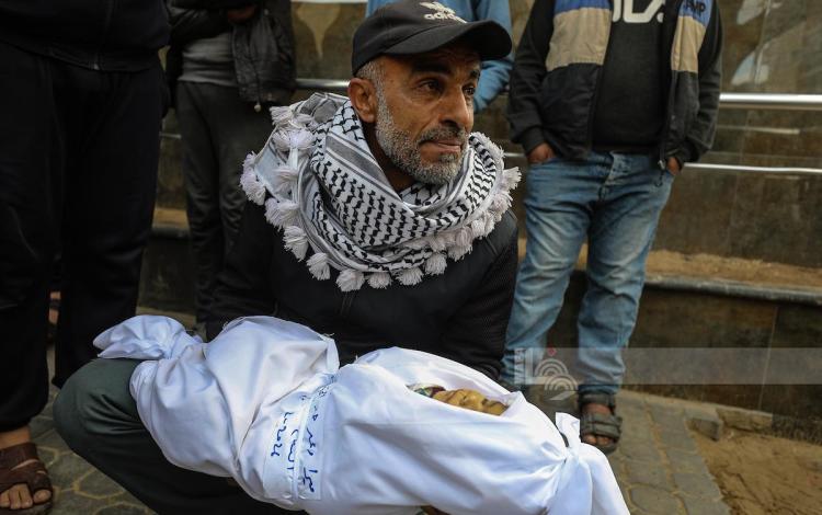 فلسطيني يحمل جثمان طفله الذي استشهد إثر غارات إسرائيلية على قطاع غزة 4/2/2026 | وفا