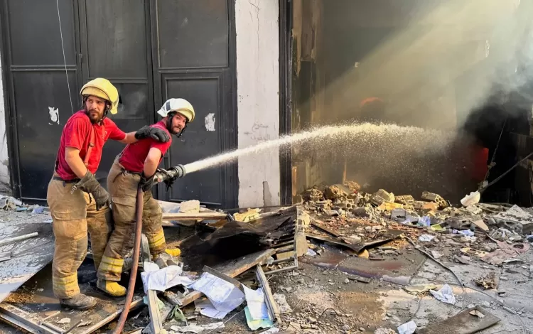 عناصر من الدفاع المدني يحاولون إخماد نيران اشتعلت في مبنى استهدفته غارة إسرائيلية في الضاحية الجنوبية لبيروت | رويترز