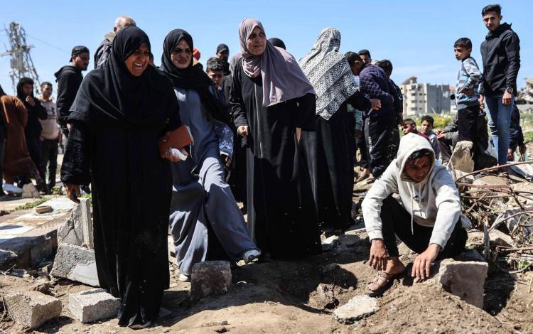 فلسطينيون حول قبر شهيدين من أقاربهم استهدفتهما غارة إسرائيلية في حي الشجاعية بمدينة غزة 28/3/2026 | وكالة الأنباء الفرنسية
