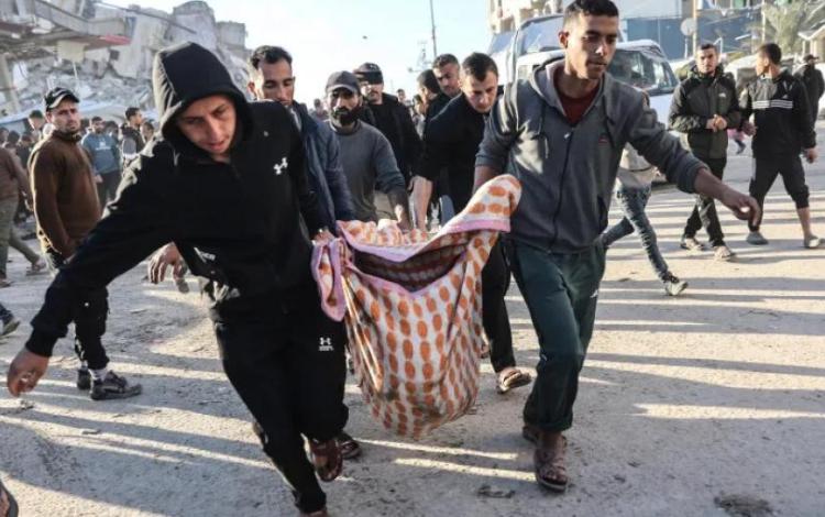 فلسطينيون يحملون جثمان أحد الشهداء بعد غارة جوية إسرائيلية على مدينة غزة 8/3/2026 | وكالة الأنباء الفرنسية