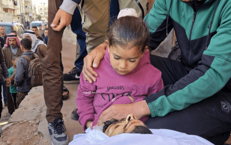 طفلة تلقي نظرة الوداع الأخيرة على والدها الذي استشهد في قصف مجموعة من الفلسطينيين على مدخل دير البلح وسط قطاع غزة 13/4/2026 | مواقع التواصل