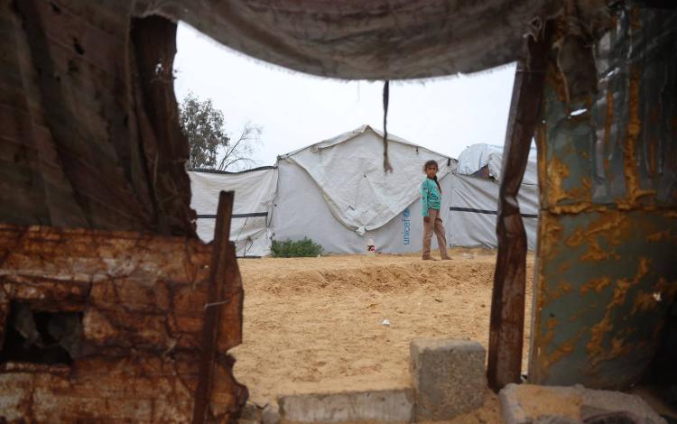 فتاة تقف في مخيم مؤقت للنازحين الفلسطينيين في منطقة نهر البارد في خانيونس بجنوب قطاع غزة | وكالة الأنباء الفرنسية