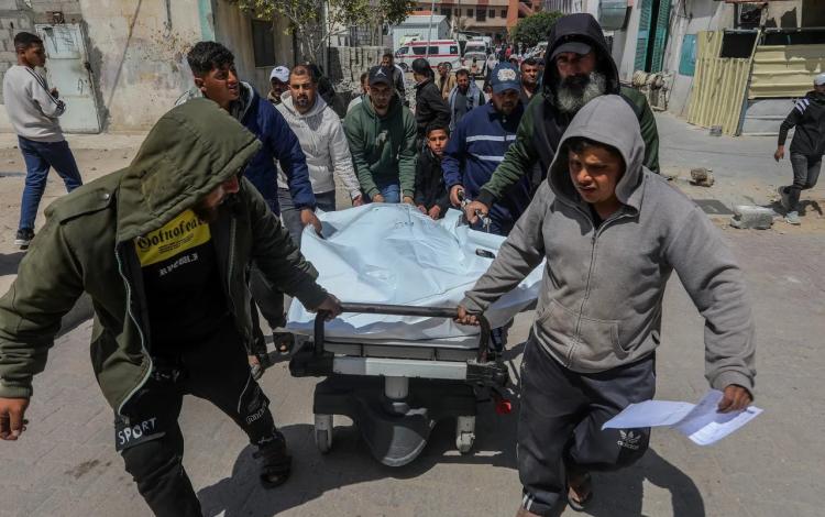 فلسطينيون ينقلون جثمان شهيد ارتقى بقصف استهدف وسط مدينة غزة 13/4/2026 | رويترز