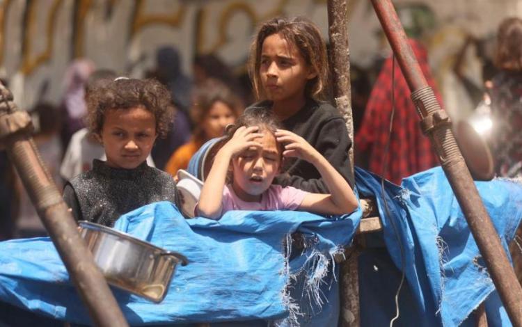 أطفال في قطاع غزة خلال انتظارهم المساعدات الغذائية | UN News