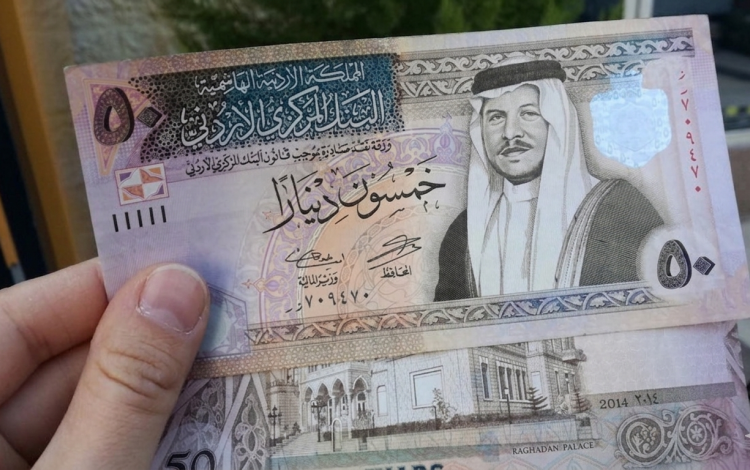 شخص يمسك بعملة أردنية من فئة 50 دينار