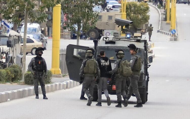 عدد من جنود الاحتلال يقتادون شابا فلسطينيا لاعتقاله | الأناضول