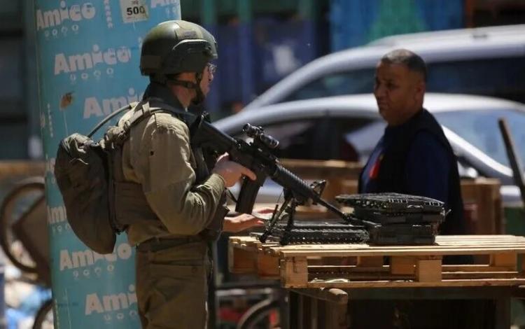 جندي من جيش الاحتلال يعيق تحرك فلسطيني في إحدى بلدات الضفة الغربية | الأناضول