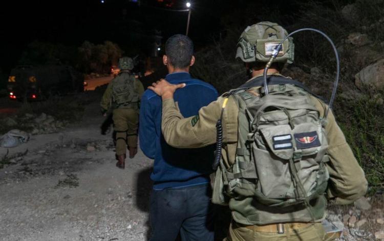 جندي من جيش الاحتلال يقتاد فلسطينيا لاعتقاله