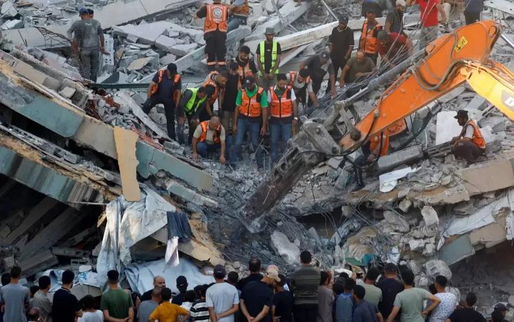 أشخاص يتجمعون فيما يحاول عناصر الدفاع المدني إنقاذ الأشخاص العالقين تحت أنقاض مبنى منهار في مدينة غزة 16/9/2026 | رويترز